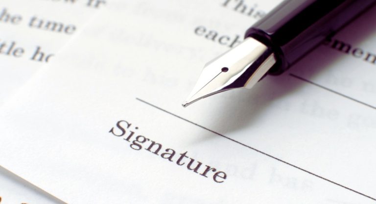 Stylo plume pose sur la ligne de signature d'un contrat