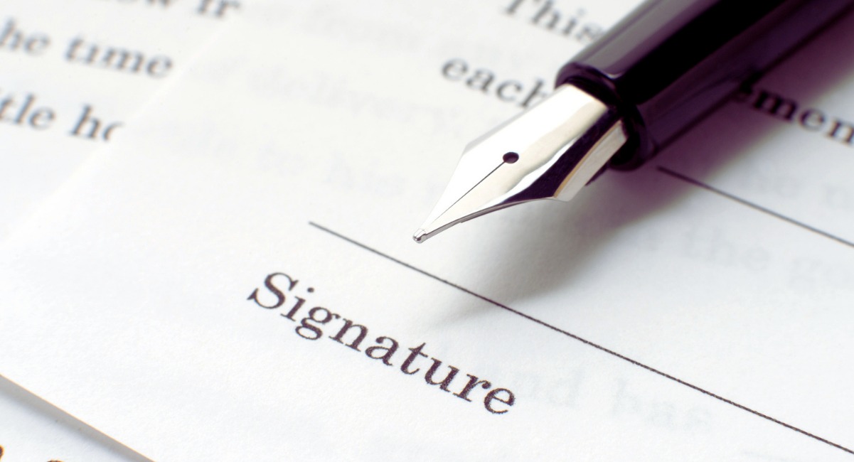 Stylo plume pose sur la ligne de signature d'un contrat