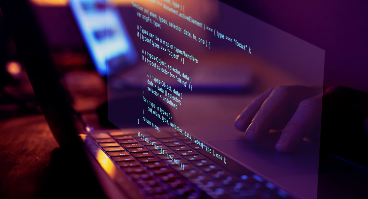 Lignes de code de programmation affichées sur un écran d'ordinateur portable illustrant la différence entre progiciel et logiciel