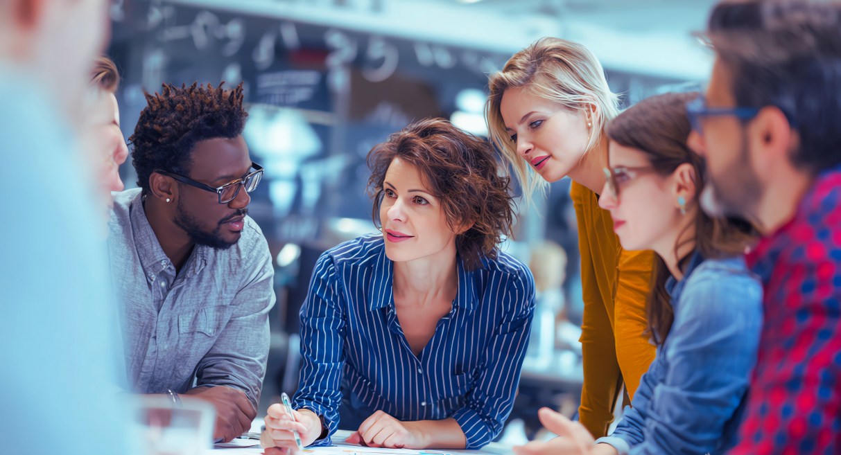 Groupe de collaborateurs en réunion stratégique autour d'une table de travail